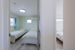 een kleine slaapkamer met 2 bedden en een spiegel bij KASILIN - Vacation STAY 16662 in Osaka