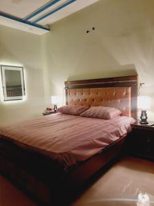 a bedroom with a large bed with two night stands and two lamps at A Exclusive Homes 2 Bed in DHA, Karachi in Karachi