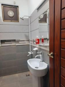 a bathroom with a toilet and a sink and a mirror at Exclusive Homes 2 Bed in DHA, Karachi in Karachi