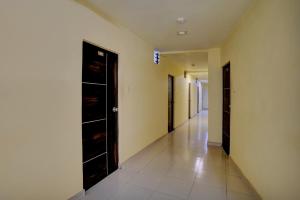 pasillo con puertas negras y suelo de baldosa en Collection O Hotel Konark Inn, en Ahmedabad