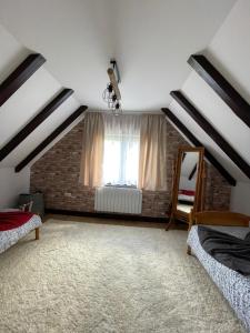 een zolderkamer met 2 bedden en een raam bij Stéph&Marry House Brodina 
