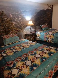 Manitou Inn في مانيتو سبرينغز: سريرين في غرفة مع لوحة على الحائط