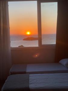 een raam met uitzicht op de oceaan en de zonsondergang bij Adil Butik Otel in Didim