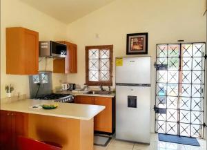 a kitchen with a white refrigerator and a counter at Gems Pool Side Chillax Stay in Portmore