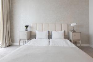 sypialnia z dużym białym łóżkiem z 2 stolikami nocnymi w obiekcie Apartament,Nowe Miasto 2pokoje, 4osoby, miejsce parkingowe,ogród zimowy w Poznaniu