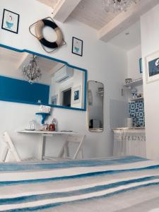 een witte kamer met een tafel en een spiegel bij Acasadelpescatore in San Benedetto del Tronto