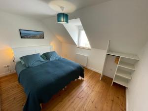 - une chambre mansardée avec un lit bleu dans l'établissement Wissant Villa Sainte Thérèse, à Wissant