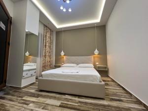 a bedroom with a large white bed and a mirror at Guest Room Angolo Toscano in Vlorë