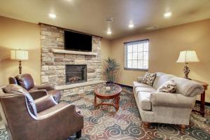 a living room with two chairs and a fireplace at Cobblestone Hotel & Suites - Salem in Salem