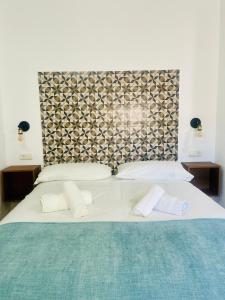 een groot bed met 2 witte kussens en een hoofdeinde bij Patio de Los Barberos 3 in Valle de Abdalagís