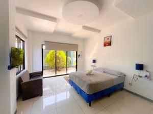 a bedroom with a bed and a large window at Casa Garitas GuestHouse - Free SJO Airport Shuttle in Santiago Este