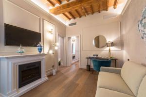 a living room with a fireplace and a flat screen tv at Palazzo 42 - Boutique Hotel & Suites in Pistoia