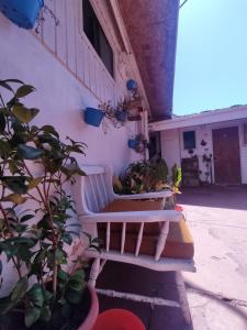 Hostal Saint Michell. El Quisco في كيسكو: جلسة مقاعد بيضاء بجانب مبنى