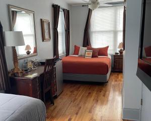 a bedroom with a bed and a desk and two windows at Ray's Bucktown Bed and Breakfast in Chicago