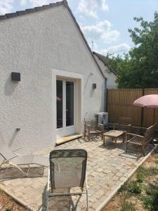un patio con sedie e tavoli e un edificio di Maison individuelle indépendante neuve 24-24h a Morigny-Champigny