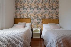 A bed or beds in a room at Casa Tarrío con Piscina - Santiago de Compostela