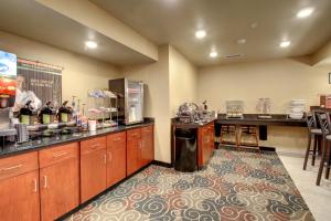a large kitchen with a counter and a bar at Cobblestone Hotel & Suites - Salem in Salem
