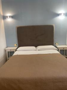 レッジョ・ディ・カラブリアにあるFata34 Luxury B&Bのサイドテーブル2台付きの部屋のベッド1台