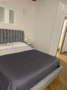 una camera con un grande letto con testiera grigia di Fata34 Luxury B&B a Reggio di Calabria