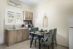 cocina con mesa, sillas y fregadero en Vicky's Apartments en Agios Gordios