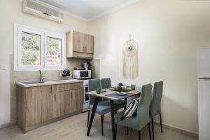 a kitchen with a table and chairs and a sink at Vicky's Apartments in Agios Gordios