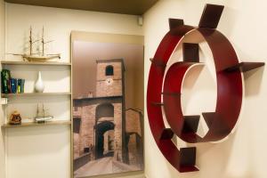 une grande sculpture rouge sur un mur à côté d'un miroir dans l'établissement Hotel ROSE NUOVE, à Rimini