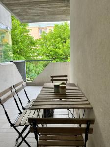 un tavolo in legno e una panca sul balcone di 5 Viale Fano Apartment a Rimini