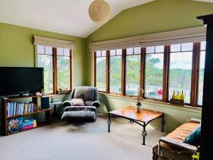 ein Wohnzimmer mit grünen Wänden und Fenstern in der Unterkunft Rural paradise 30 mins from Auckland CBD in Auckland