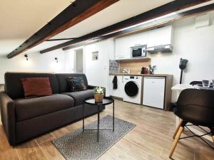 ein Wohnzimmer mit einem Sofa und einer Küche in der Unterkunft Le Tropical l Calme l Clim l Parking gratuit in Istres