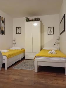 - 2 lits dans une chambre blanche avec des draps jaunes dans l'établissement Studio Sofia 2, à Novalja