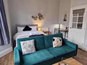 ニューカッスル・アポン・タインにあるWest Beck House - Newcastle 2のリビングルーム(緑のソファ、ベッド付)
