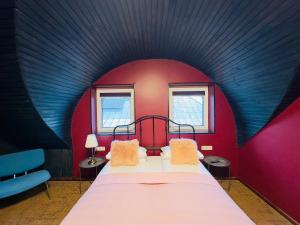 een slaapkamer met een bed met een rode muur bij Broken bed hootel in Kaunas