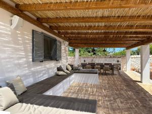 Un patio con un sofá y un televisor en una pared. en Trullo Gemma, en Martina Franca