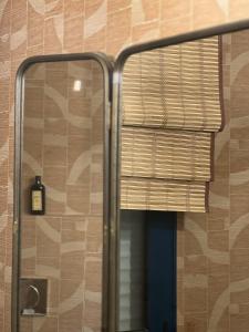 a shower with a glass door and a window with a bottle at 5 Viale Fano Apartment in Rimini