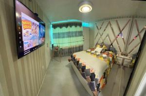 a bedroom with a bed and a large screen at Gold House Oro in Quito