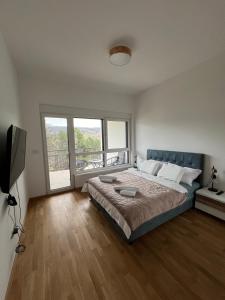 a bedroom with a large bed and a large window at Apartman 103 in Vrdnik