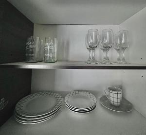 a shelf with plates and wine glasses on it at Centro Temuco 3 in Temuco +6 photos
