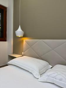 a bed with white sheets and a white headboard at Guest Room Angolo Toscano in Vlorë