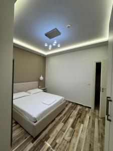 a bedroom with a white bed and a ceiling at Guest Room Angolo Toscano in Vlorë