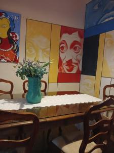 una mesa con un jarrón de flores. en Brumas Ouro Preto Hostel e Pousada en Ouro Preto