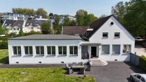 een wit huis met veel ramen bij Villa direkt am Baldeneysee in Essen