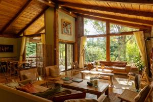 a living room with couches and tables and windows at PURA Hotel in Coihaique