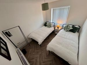 um pequeno quarto com 2 camas e um espelho em The perfect place em Barnsley