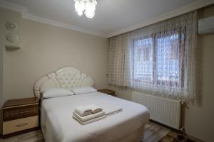 a bedroom with a white bed and a window at Çaykara Mutlu Apart in Çaykara