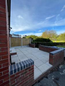 um pátio com uma parede de tijolos e bancos em The perfect place em Barnsley