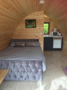 a bedroom with a bed in a wooden cabin at Murphys Glamping Pod in Cork
