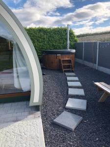 a garden with a stone path and a hot tub at Murphys Glamping Pod in Cork
