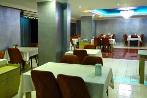 Arsin的住宿－Yıldız Moonlight Hotel Trabzon，用餐室配有白色桌椅和桌子。