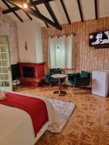 um quarto com uma cama, uma mesa e cadeiras em Pousada Brisa da Mantiqueira em Monte Verde