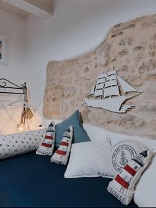 łóżko z poduszkami i statek na ścianie w obiekcie Acasadelpescatore w mieście San Benedetto del Tronto